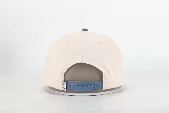 Beige cap with a blue strap on a light gray background